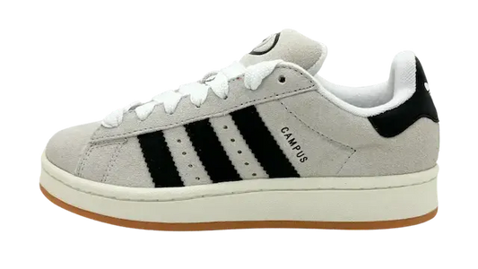 Een beige suède sneaker met zwarte strepen, witte tussenzool en rubberen zool. Het woord "CAMPUS" is op de zijkant gedrukt, wat de klassieke Adidas Campus 00s (W) Crystal White/Black-stijl laat zien.