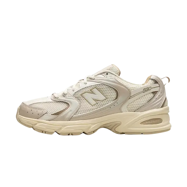 Zijaanzicht van een New Balance 530 Beige Angora atletische sneaker met een bovenwerk van mesh, witte veters en een gedempte zool met een prominent "N" logo aan de zijkant, die stijl en comfort biedt.