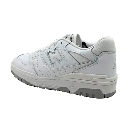 Een New Balance 550 wit/grijze sneaker met een geperforeerd bovenwerk, grijze buitenzool en zichtbare branding op de zijkant en zool straalt tijdloze klasse uit tegen een zwarte achtergrond.