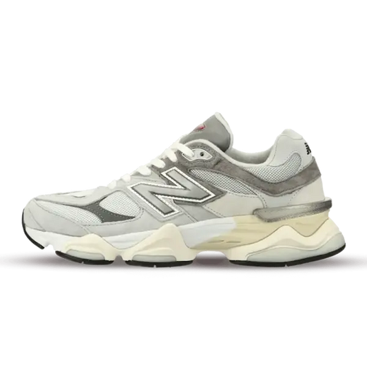 Een wit-grijze New Balance-sneaker met 'N'-logo op de zijkant, een dikke zool en mesh-panelen in Rain Cloud Grey.